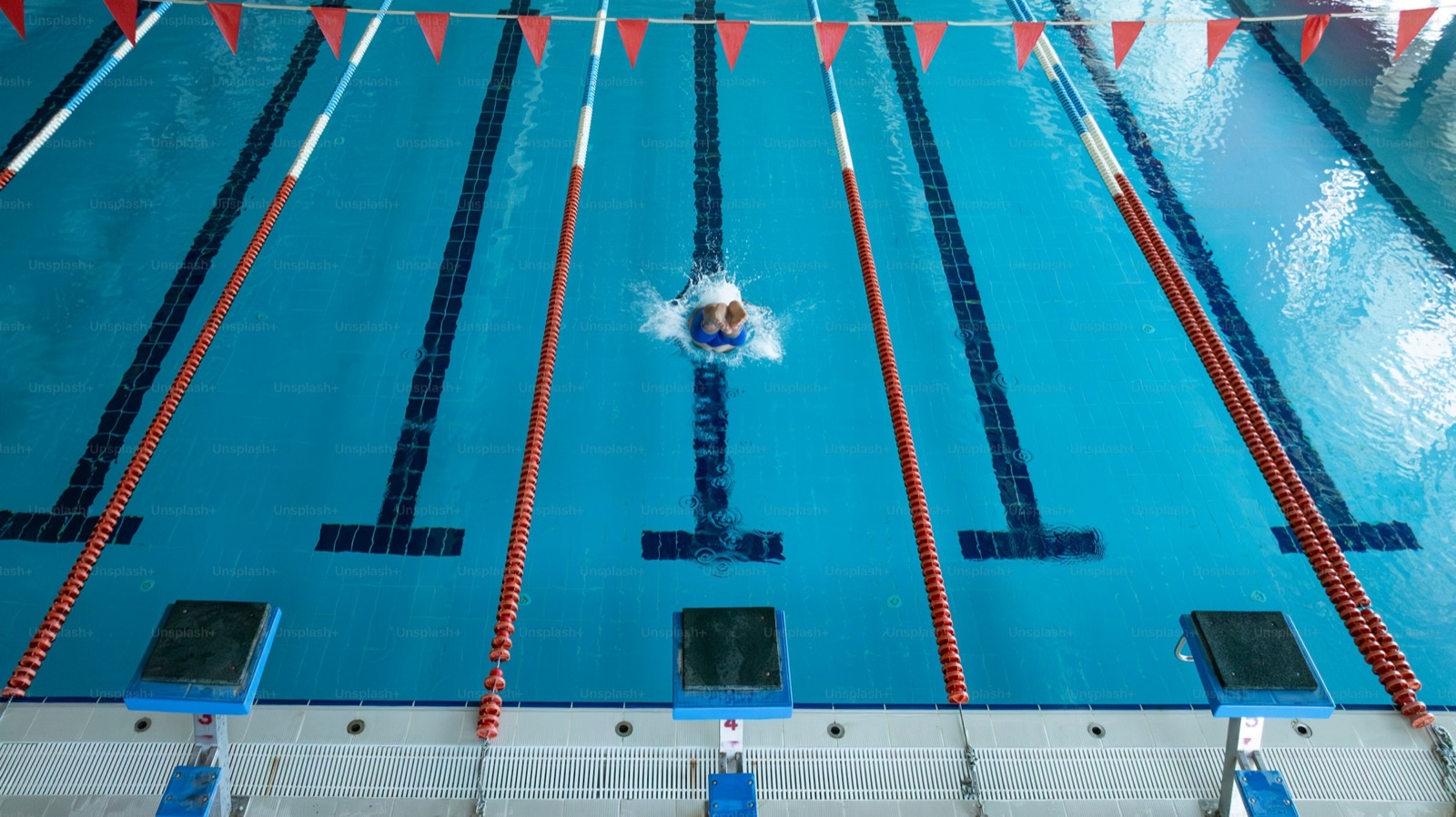 Image size 1600x900. Swimmer holding a steady pace in a lap pool.