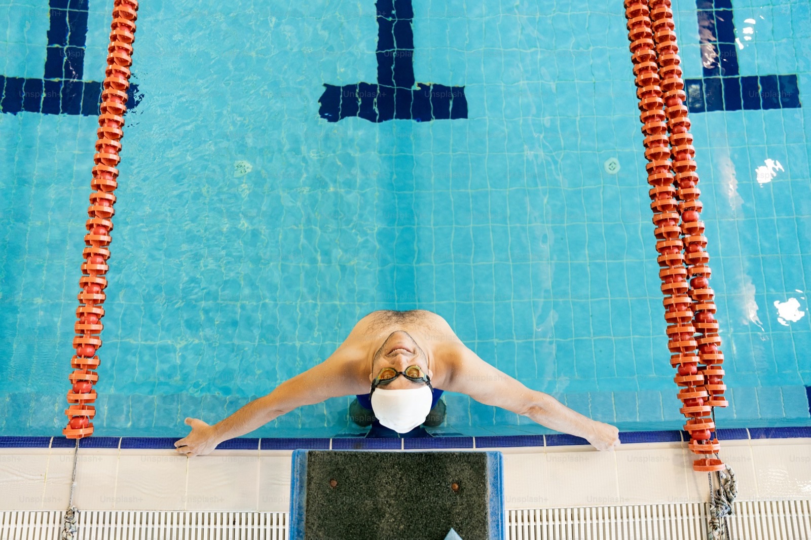 Image size 1600x900. Swimmer cruising steady endurance laps in a lap pool.